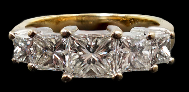 A modern 18ct gold and graduated five stone princess cut diamond set half hoop ring